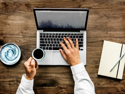 aerial-view-man-using-computer-laptop-wooden-table_53876-165171