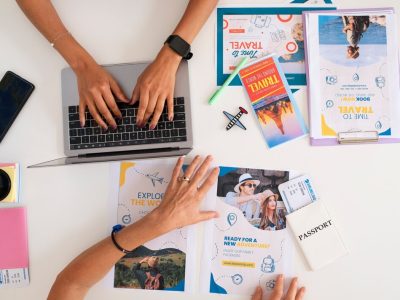 top-view-travel-agency-desk-with-people-working-laptop_52683-137901